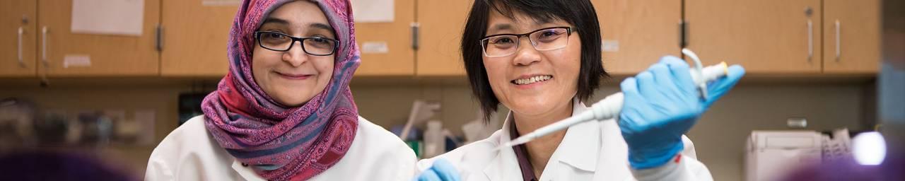 Prof. Khoo and student pose in her lab.